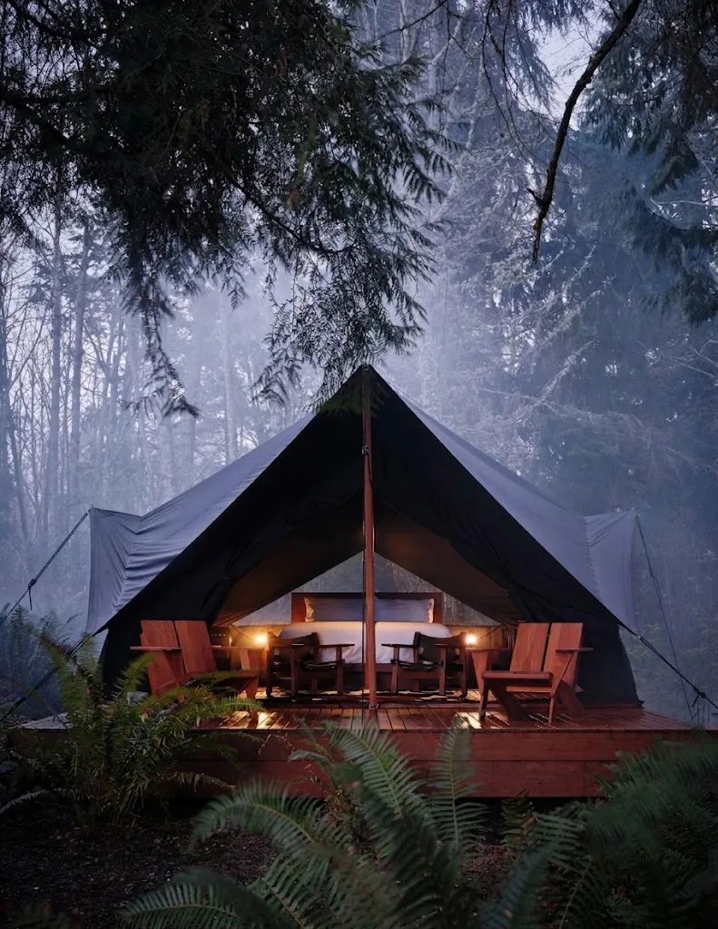 Lit canvas tent at dusk in the forest
