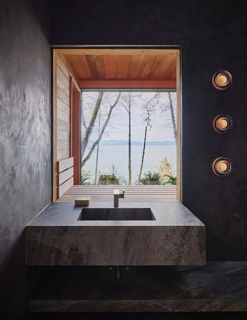 Bathhouse interior with stone basin and a window to the sea
